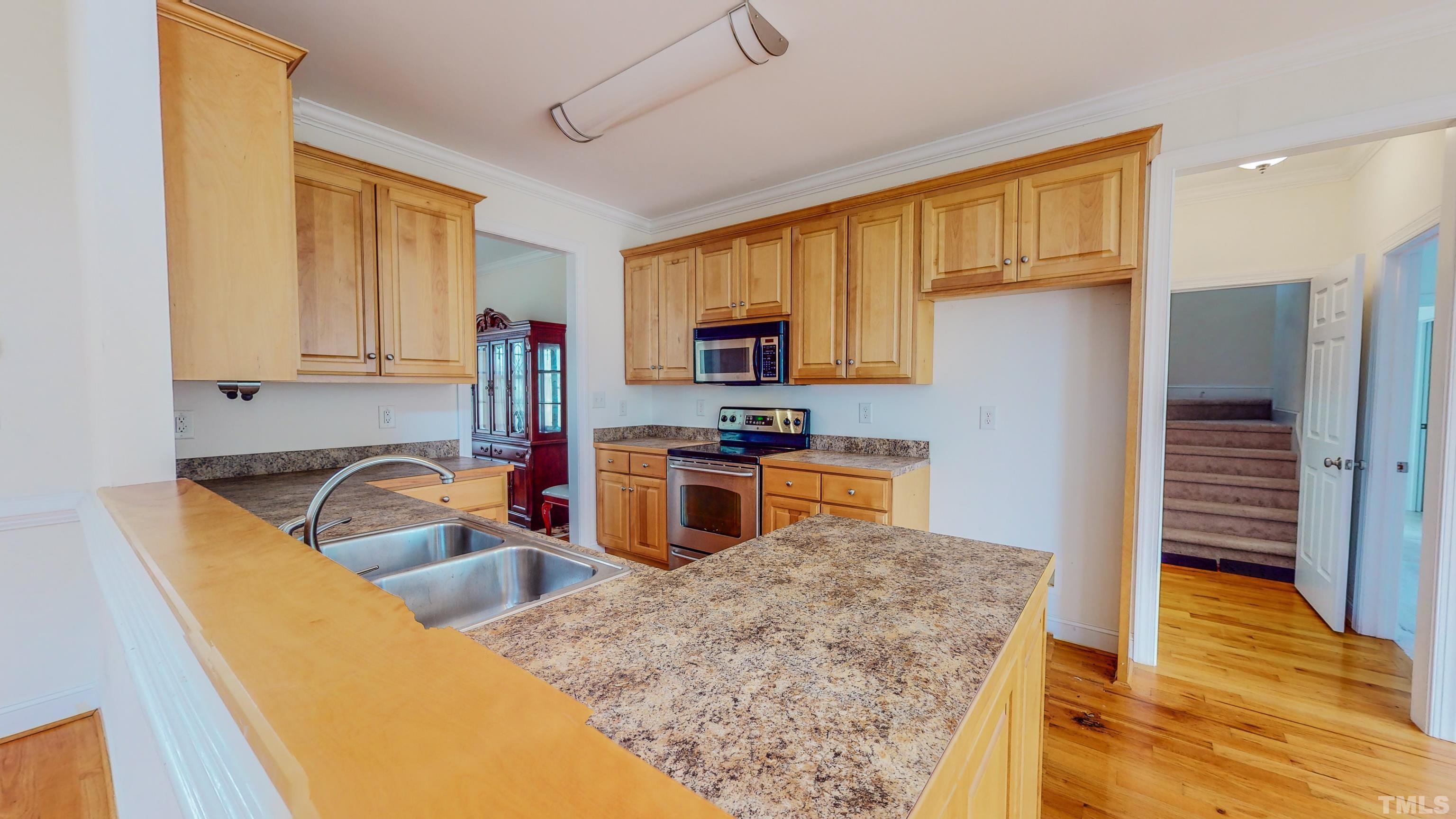 134 Fletcher Ridge Road Timberlake, NC 27583 - Photo 4 of 52 a kitchen with granite countertop a stove a sink and a microwave