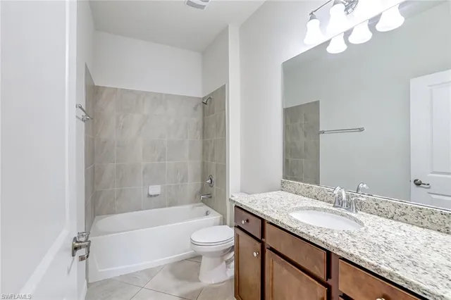 a bathroom with a granite countertop sink a toilet and bathtub
