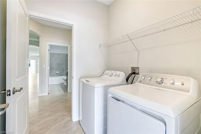 a view of washer and dryer with bathroom in the background