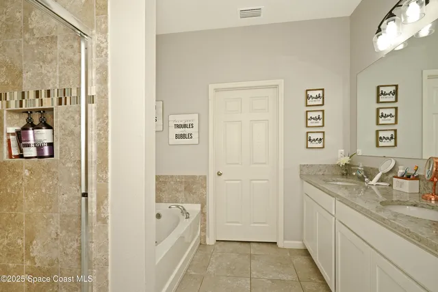 a bathroom with a granite countertop sink a mirror a bathtub and a shower