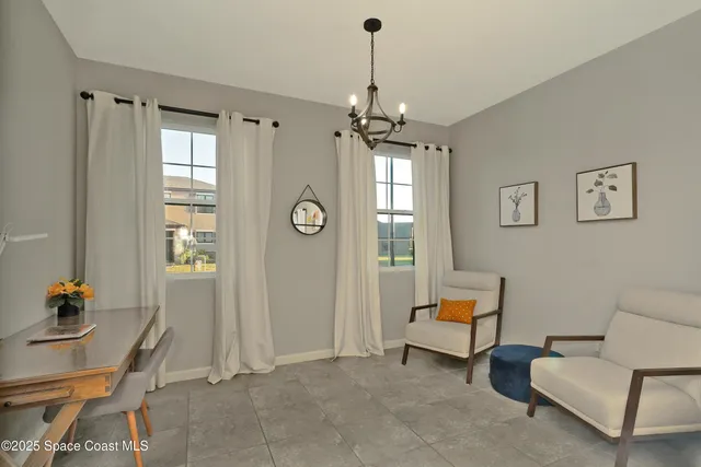 a living room with furniture a window and a chandelier