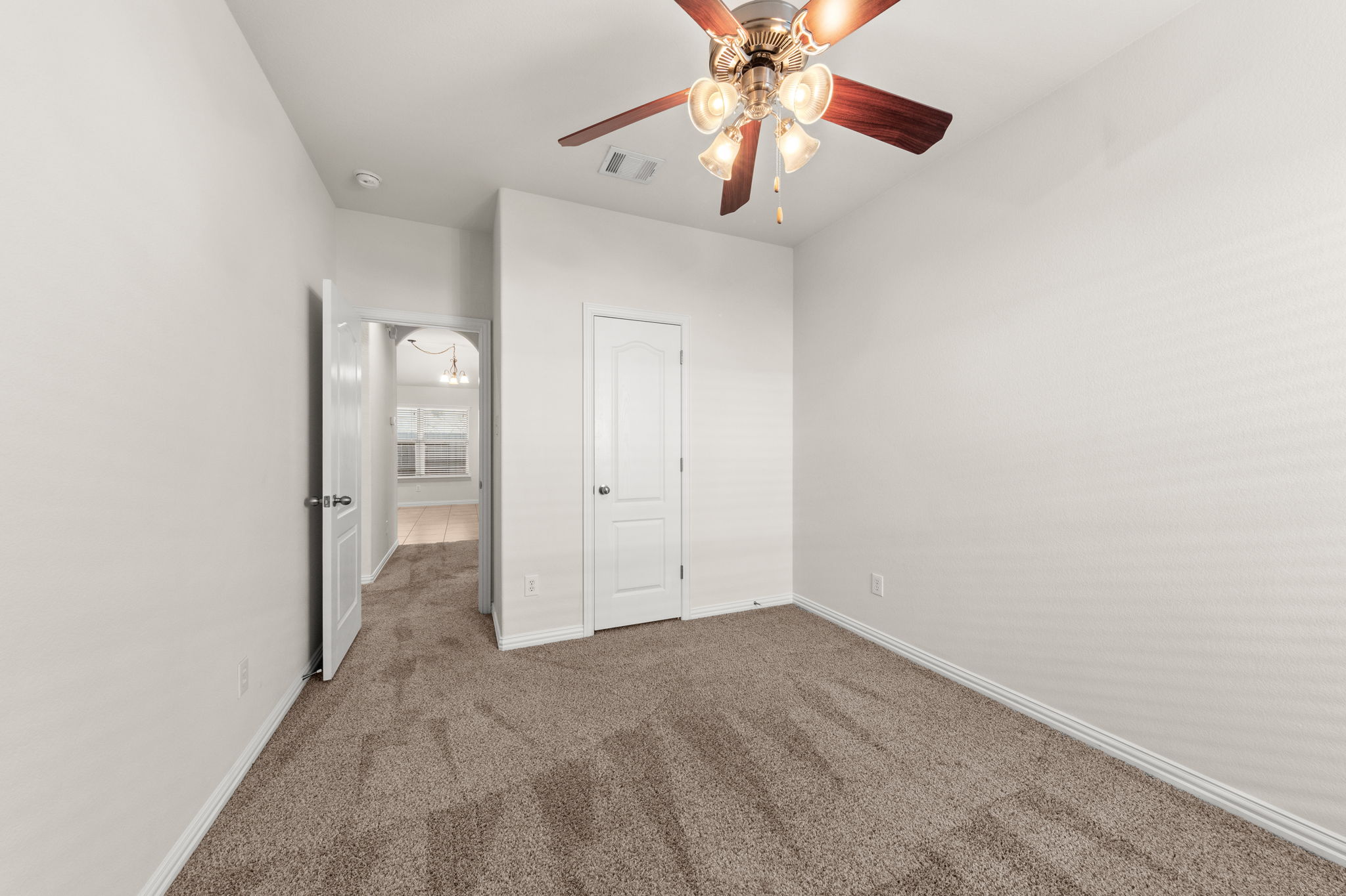 411 Tascate Street Georgetown, TX 78628 - Photo 27 of 41 A well-lit room awaits your personal touch, featuring soft carpeting and an overhead ceiling fan.