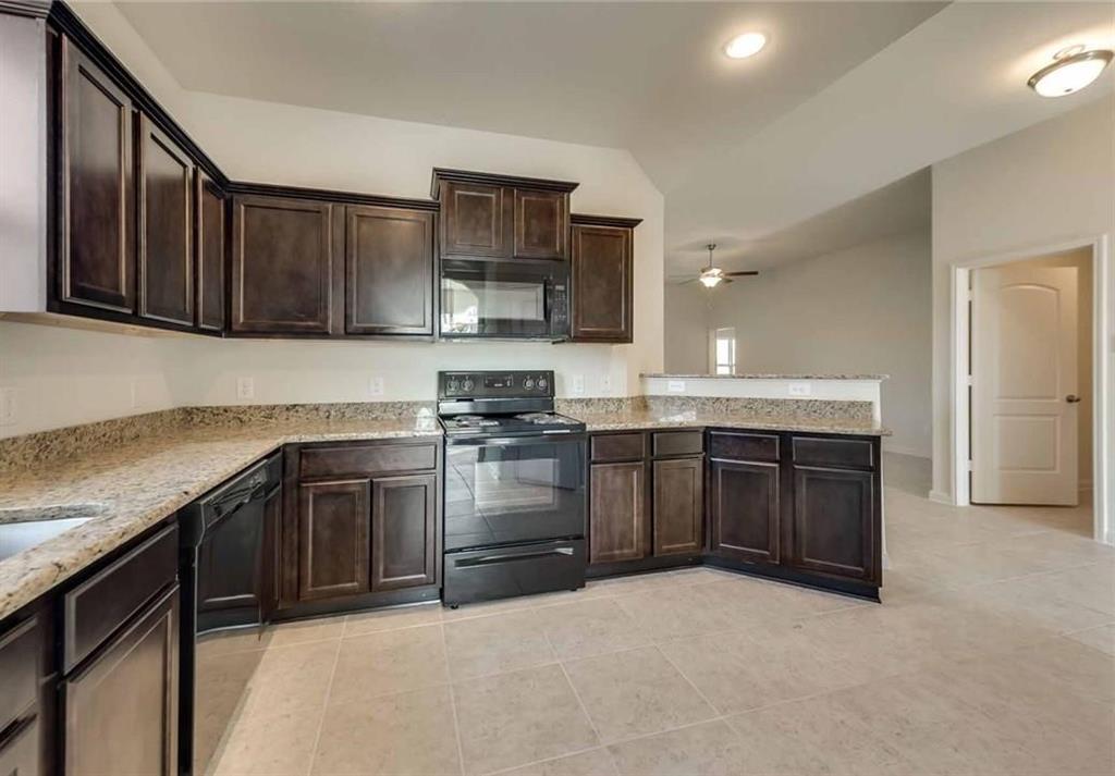 4720 Merchant Trail Denton, TX 76207 - Photo 2 of 13 a kitchen with stainless steel appliances granite countertop a stove a sink and a refrigerator