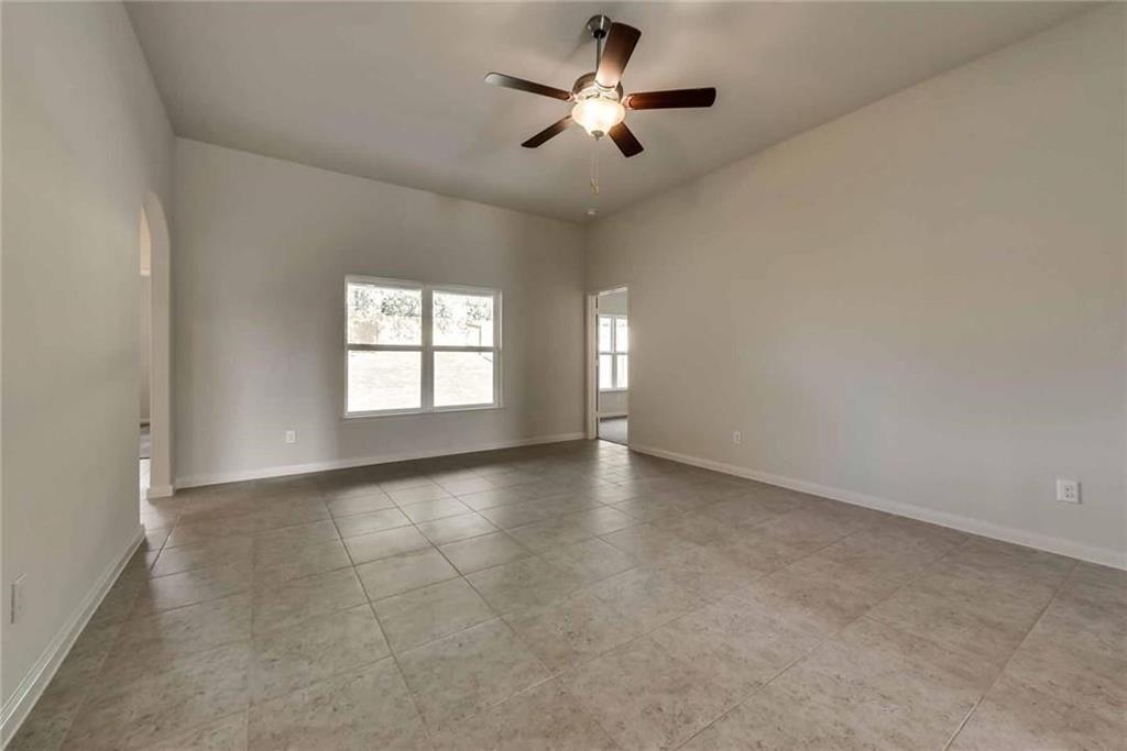 4720 Merchant Trail Denton, TX 76207 - Photo 5 of 13 an empty room with windows and ceiling fan