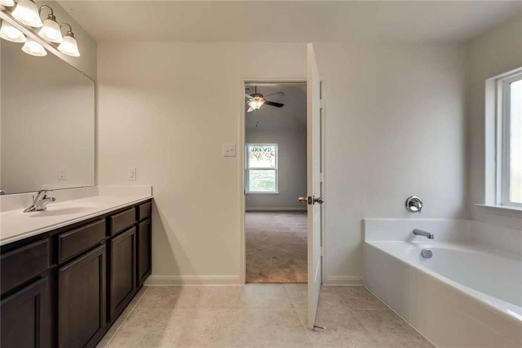 4720 Merchant Trail Denton, TX 76207 - Photo 10 of 13 a bathroom with a tub sink and mirror