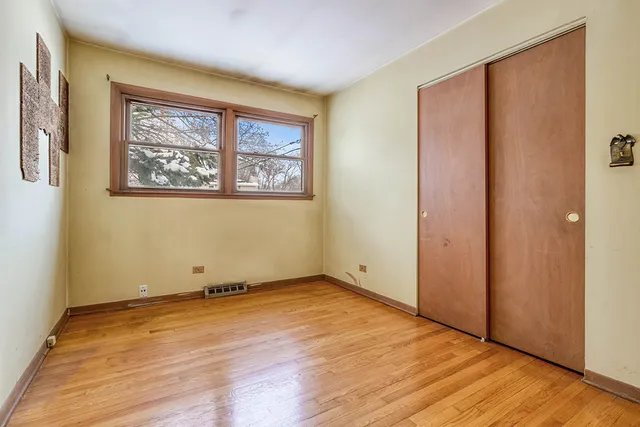 an empty room with wooden floor and window