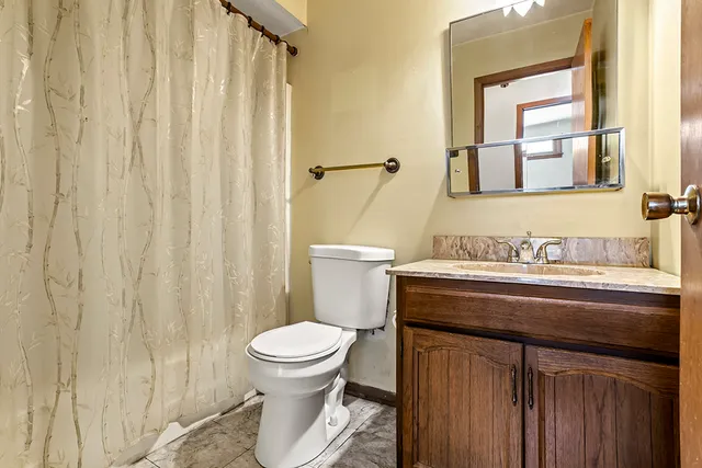 a bathroom with a granite countertop sink toilet and a mirror