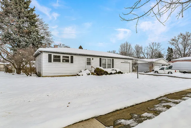 a front view of a house with yard covered in snow