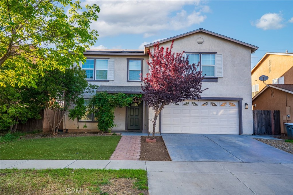 a front view of a house with a yard and trees