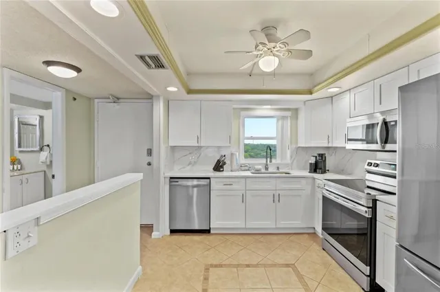 a kitchen with stainless steel appliances granite countertop a refrigerator a stove a sink and dishwasher