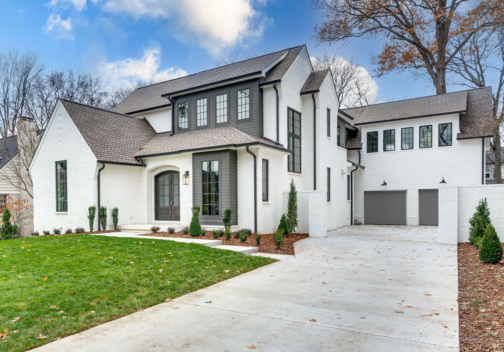 a front view of a house with a yard and trees