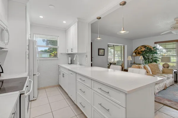 a kitchen with stainless steel appliances granite countertop a white cabinets a stove a sink and a refrigerator