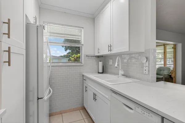 a kitchen with white cabinets and chandelier