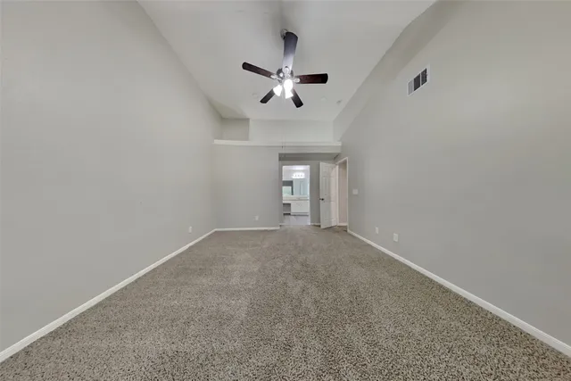 en empty room with ceiling fan and window