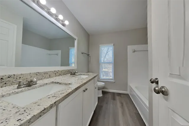 a bathroom with a granite countertop double vanity sink and a mirror