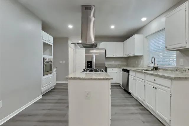 a kitchen with stainless steel appliances granite countertop a sink and cabinets