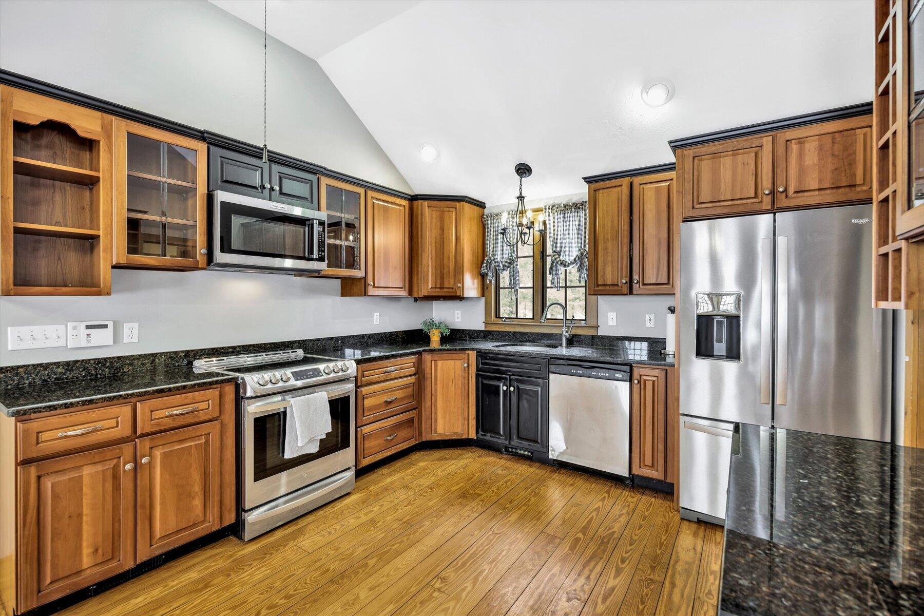 85 Clamshell Cove Road Cotuit, MA 02635 - Photo 5 of 46 a kitchen with stainless steel appliances granite countertop a refrigerator a stove top oven a sink and dishwasher