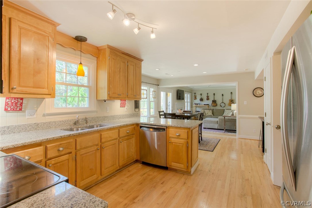 15201 Powell Grove Road Midlothian, VA 23112 - Photo 8 of 27 a kitchen with stainless steel appliances granite countertop a refrigerator a sink dishwasher a stove and white countertops with wooden floor