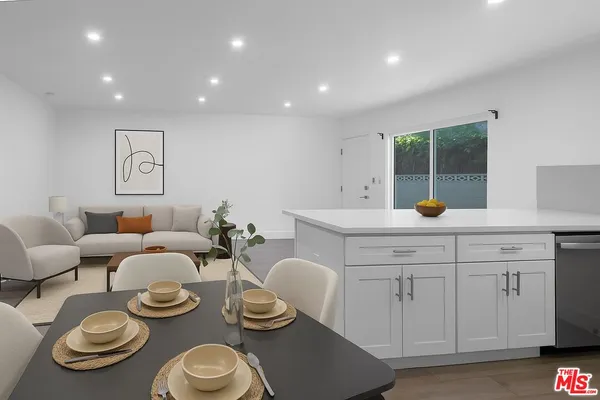 a kitchen with stainless steel appliances a white table and chairs