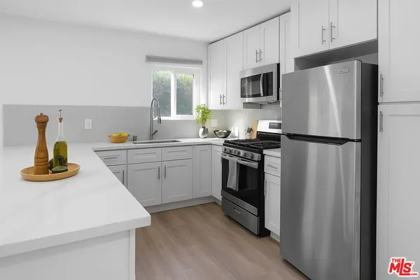 a kitchen with a sink appliances and cabinets