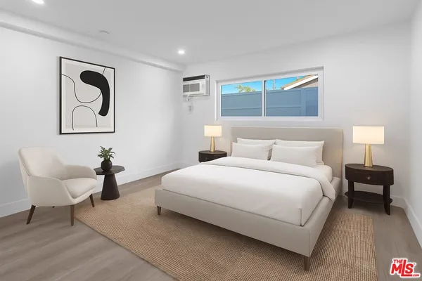 a bedroom with a bed and a painting on the wall