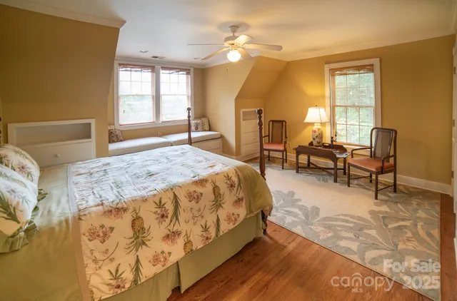 a spacious bedroom with a bed a table and windows