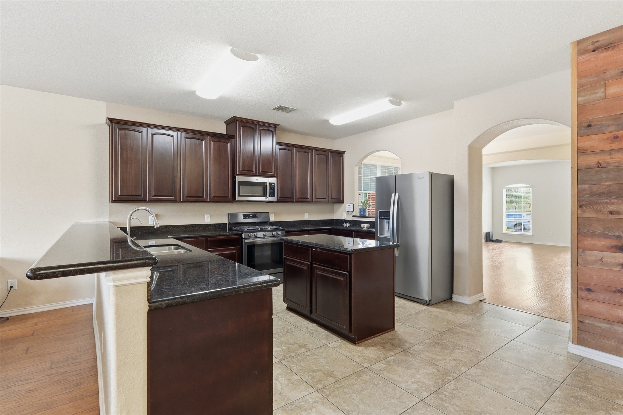 8234 Nagy Hill Street Spring, TX 77379 - Photo 3 of 32 Spacious open-concept kitchen featuring rich wood cabinetry, granite countertops, stainless steel appliances, a gas range, and a large center island