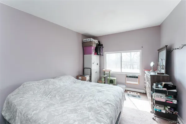 a bedroom with a bed a table and large windows