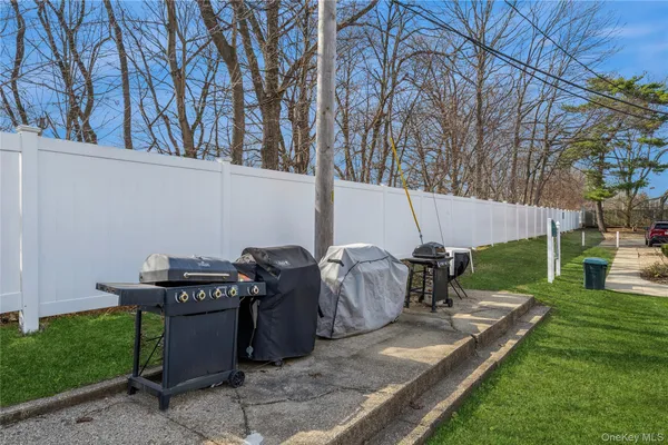 a view of a backyard with couches under an umbrella