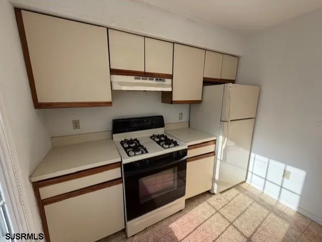 a kitchen with kitchen island a stove a sink and a refrigerator