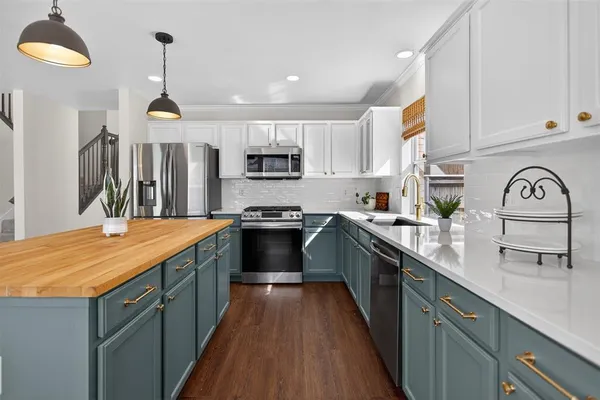 a kitchen with kitchen island granite countertop a sink a counter top space stainless steel appliances and cabinets