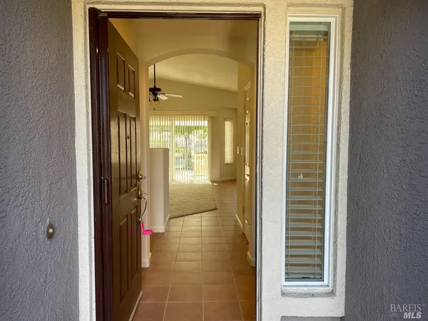 a view of a hallway with a glass door and a bathroom