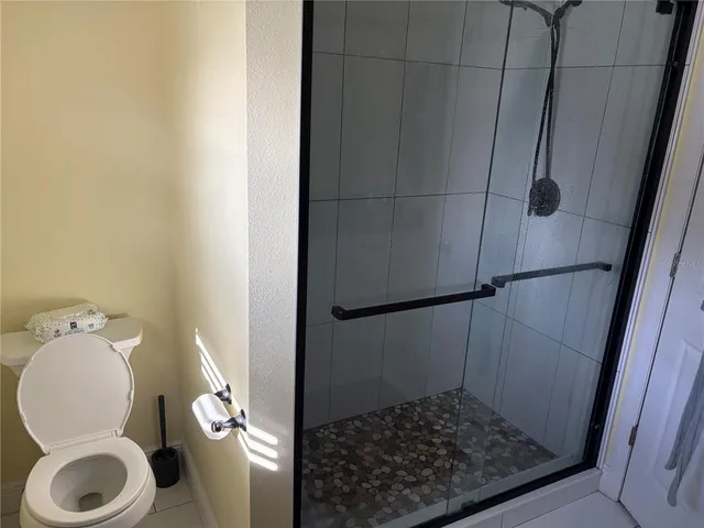 a bathroom with a toilet and a shower