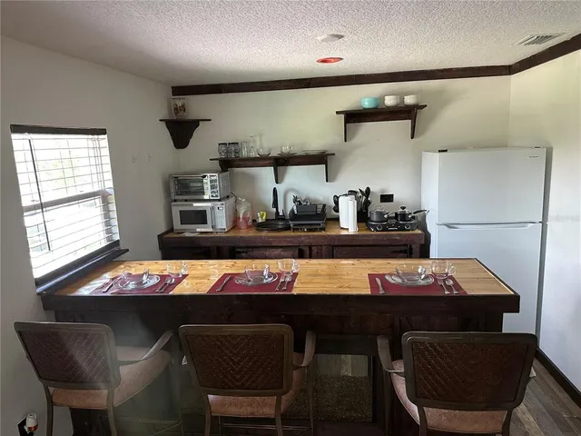 a room with stainless steel appliances dining table and chairs