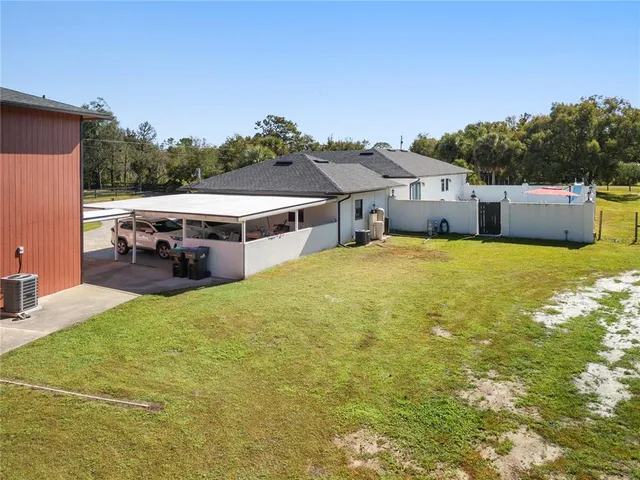 a view of a house with pool and a yard