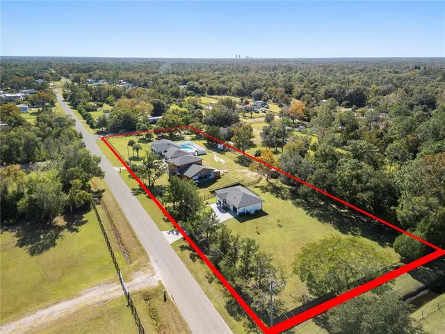 an aerial view of residential houses with outdoor space and lakeside