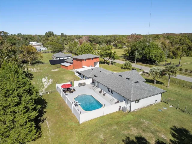 an aerial view of a house with swimming pool in front of it