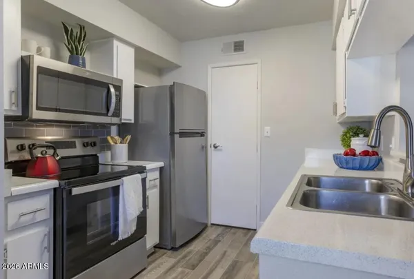 a kitchen with stainless steel appliances kitchen island granite countertop a refrigerator stove and sink