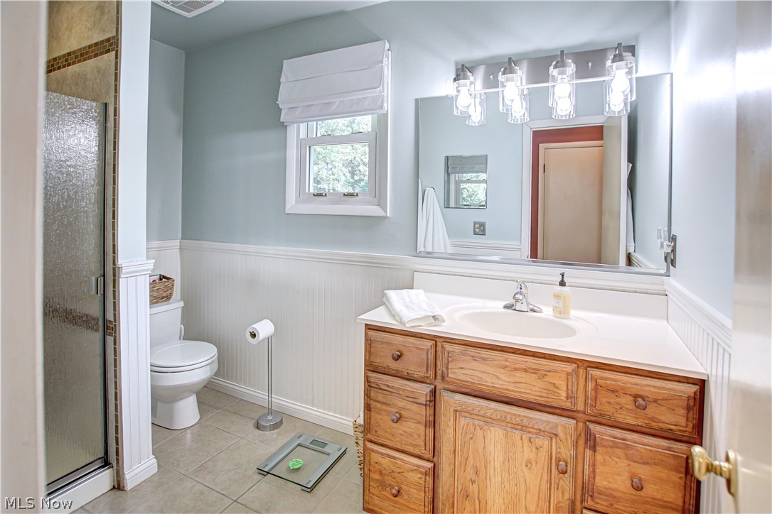 910 Andrews Road Medina, OH 44256 - Photo 26 of 45 Bathroom featuring tile floors, an enclosed shower, toilet, and vanity with extensive cabinet space