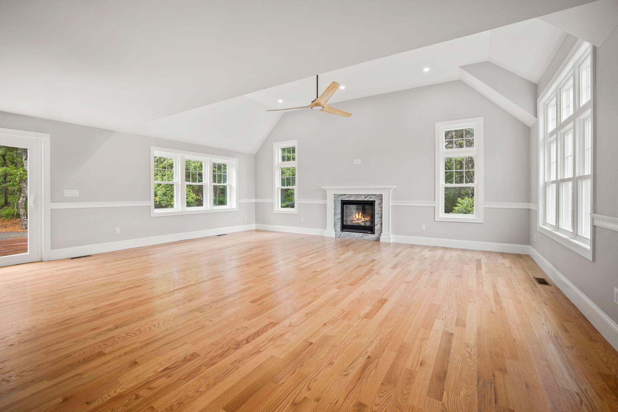 Undisclosed Address Sagamore Beach, MA 02562 - Photo 29 of 43 an empty room with wooden floor fireplace and windows