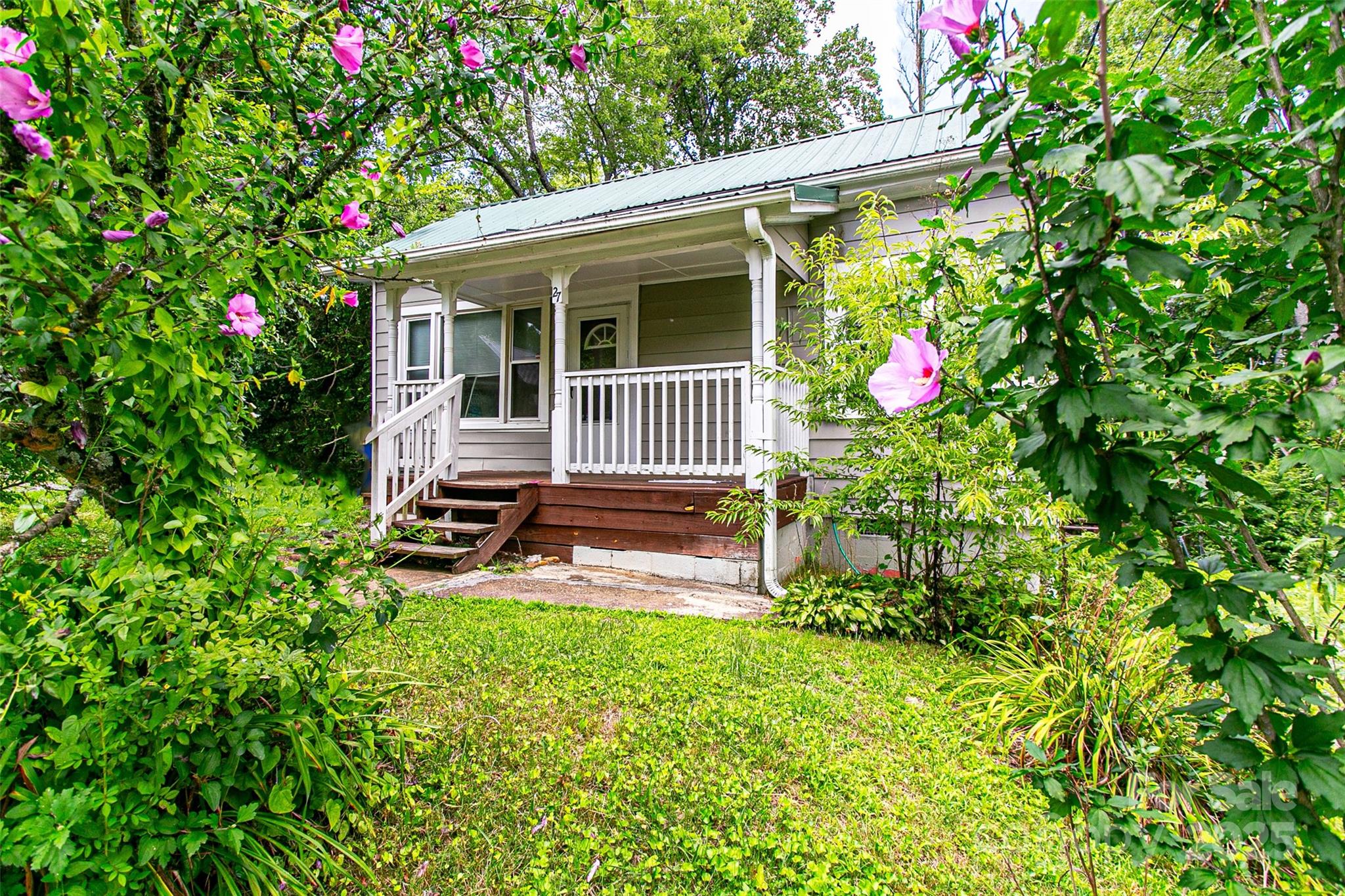 a backyard of a house with table and chairs and wooden fence