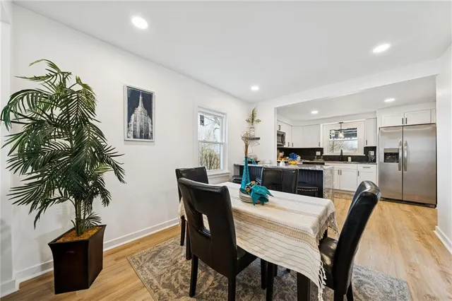 a dining room with furniture and kitchen view