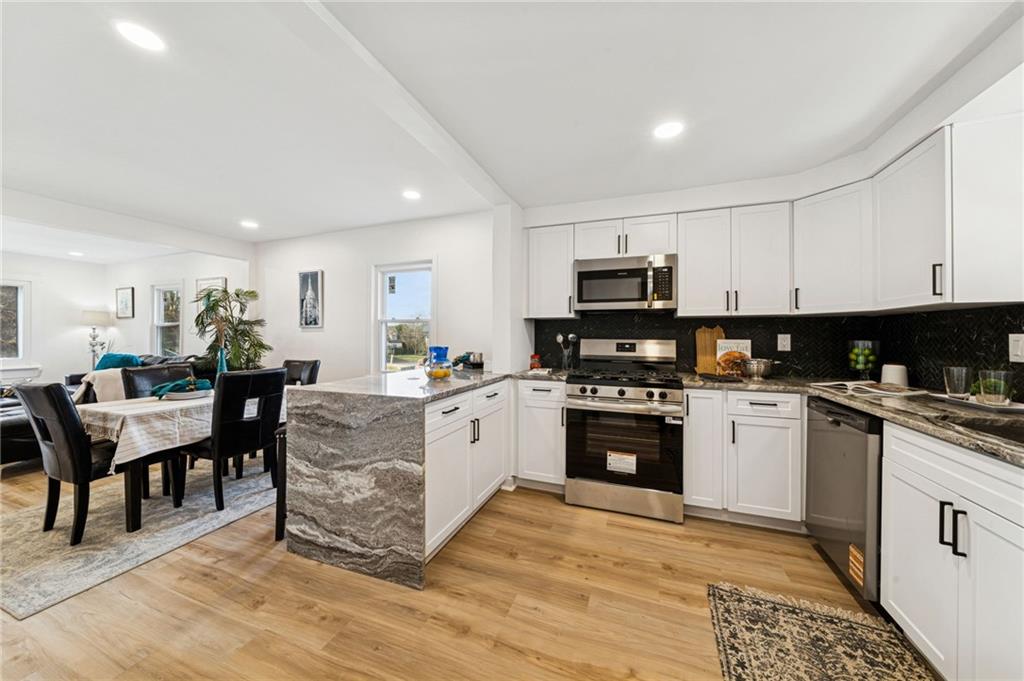 3230 Brodhead Road Aliquippa, PA 15001 - Photo 9 of 38 a kitchen with granite countertop a stove top oven a sink a dining table and chairs