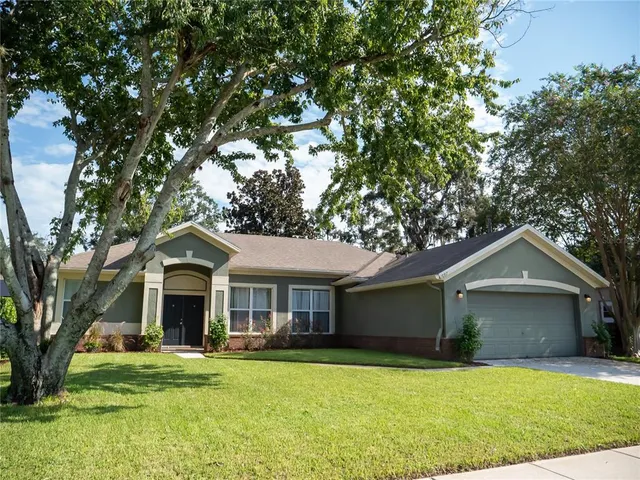 a front view of a house with a garden and yard