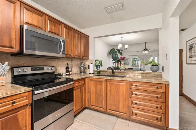 a kitchen with stainless steel appliances granite countertop a sink and a window