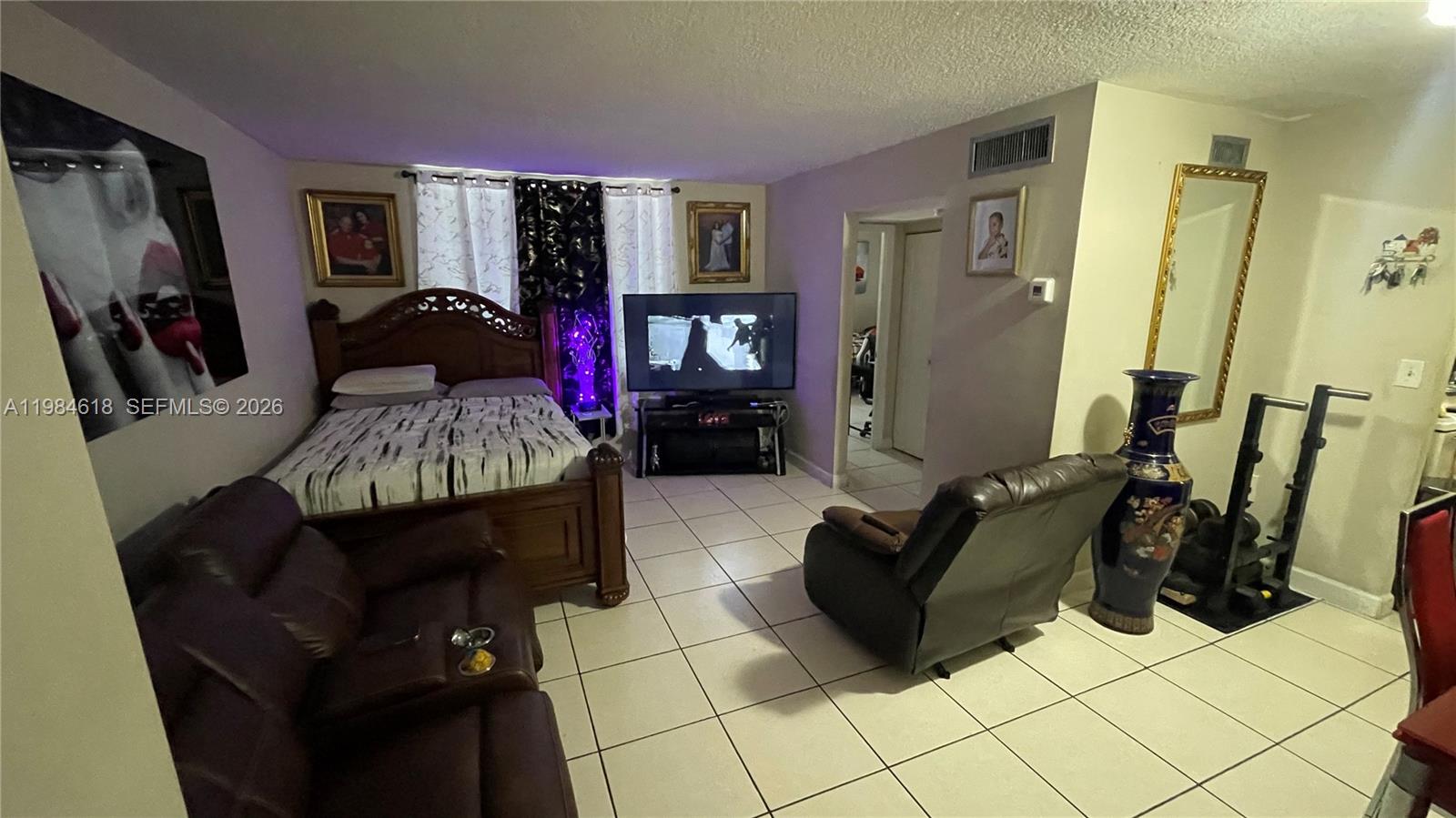 1805 West 56th Street, Unit 113 Hialeah, FL 33012 - Photo 3 of 11 a living room with furniture and a flat screen tv