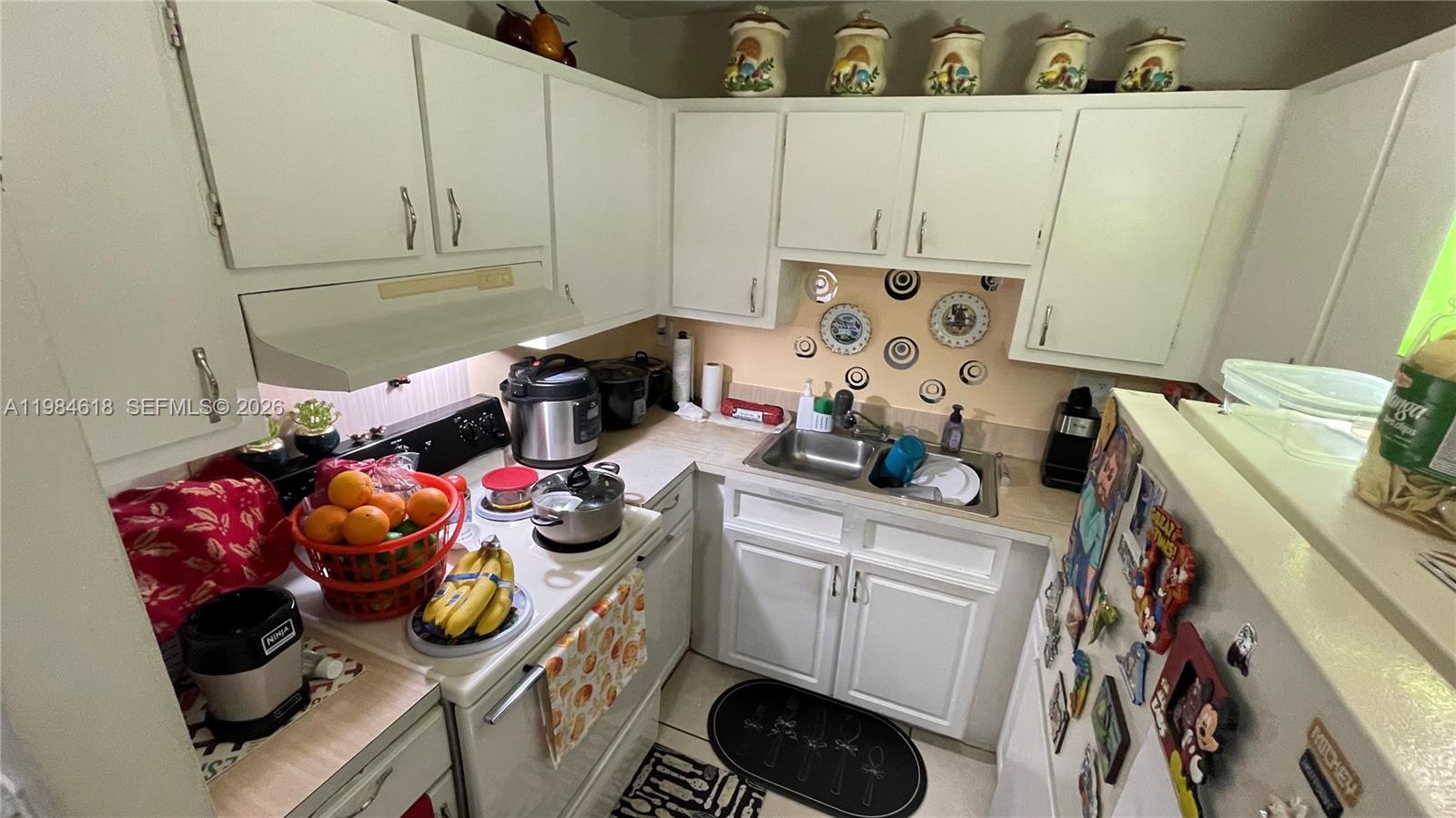1805 West 56th Street, Unit 113 Hialeah, FL 33012 - Photo 5 of 11 a kitchen with a sink a stove and cabinets