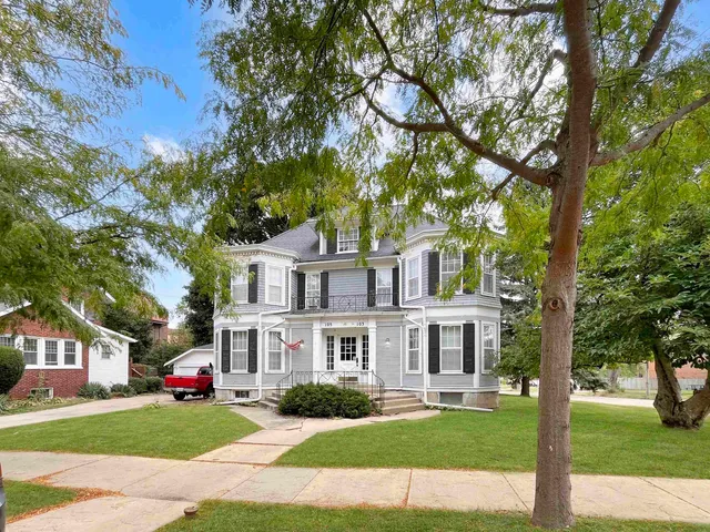 a front view of a house with a garden and plants