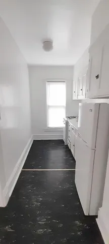 a living room with stainless steel appliances furniture a rug and a window