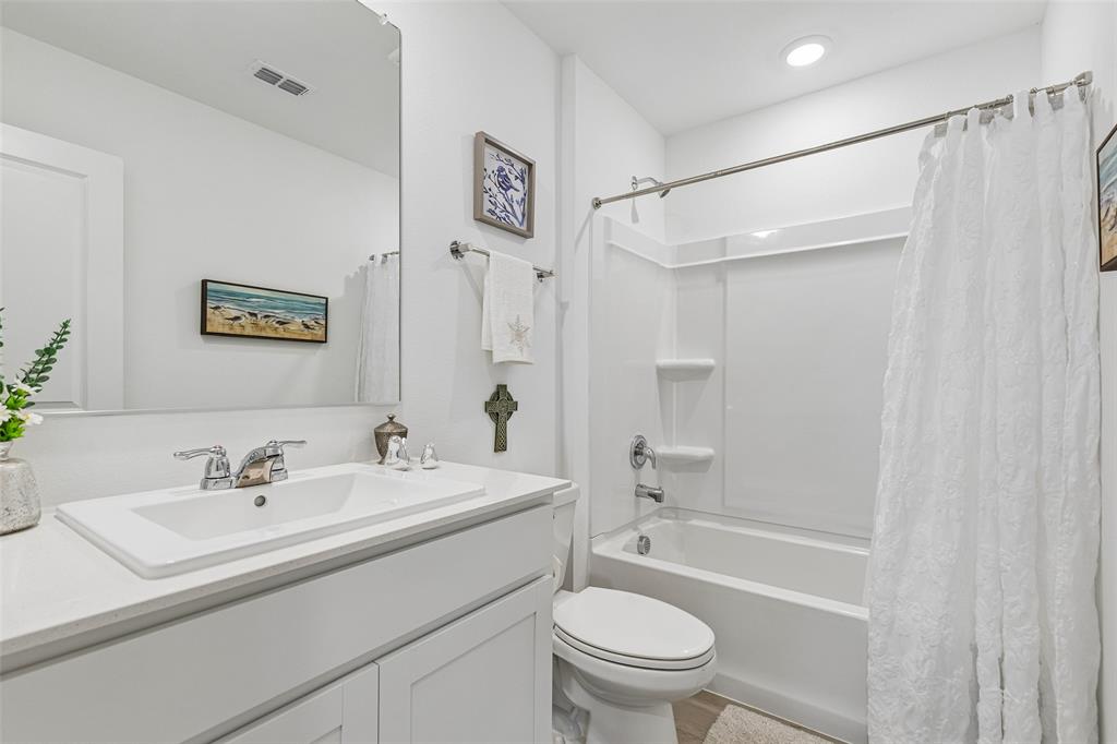 14163 Kempt Drive Pilot Point, TX 76258 - Photo 17 of 29 Full secondary bathroom featuring a spacious vanity, ample counter space, and a tub-shower combination conveniently located near the secondary bedrooms.